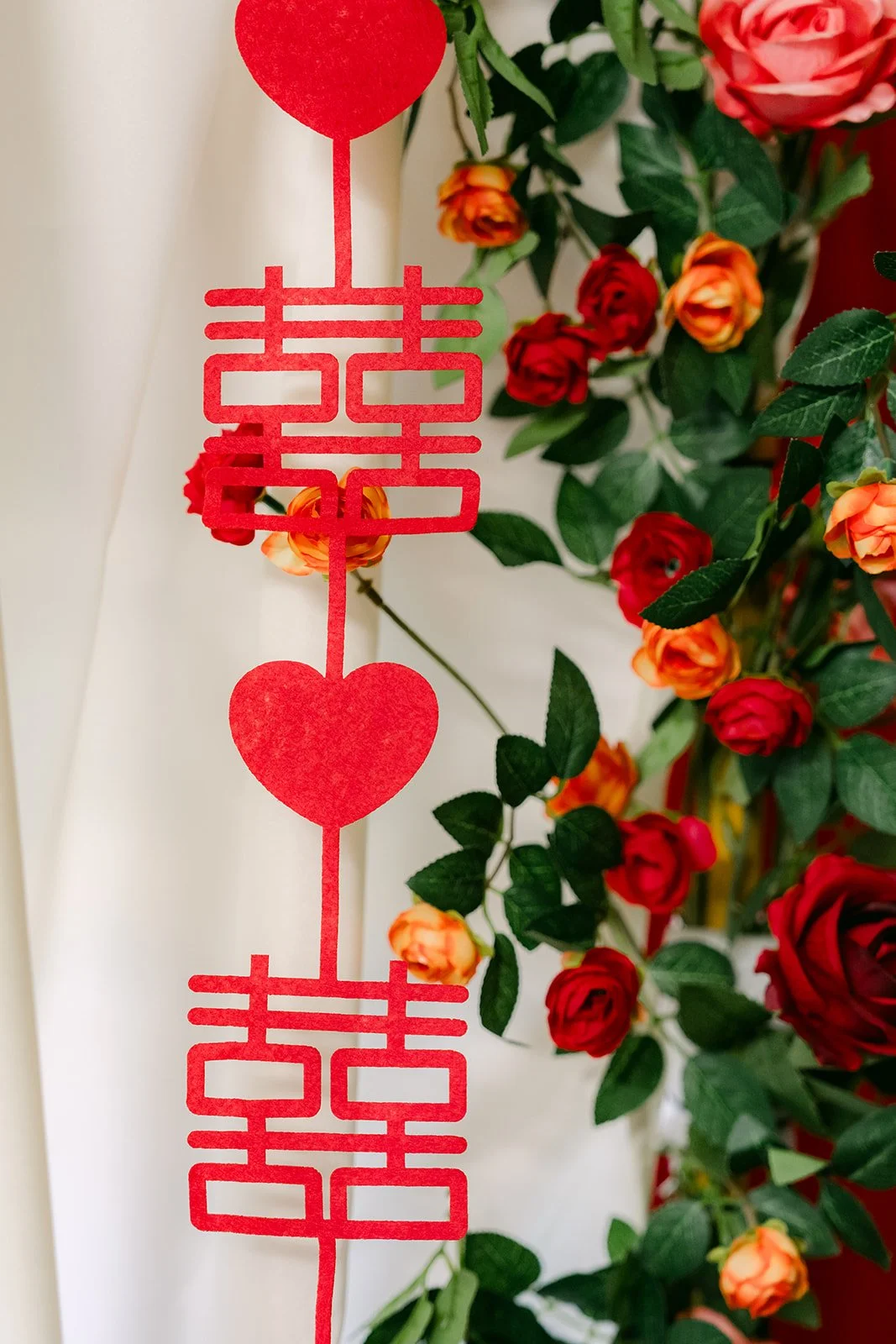 Close-up of the double happiness symbols and red roses.