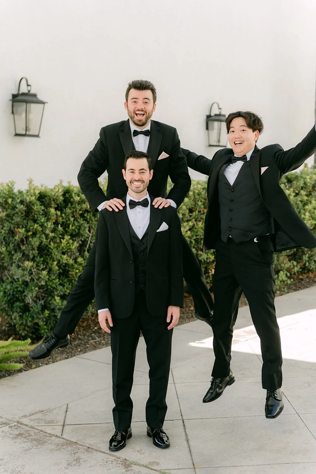 Kevin and his groomsmen striking a playful pose by the hedge