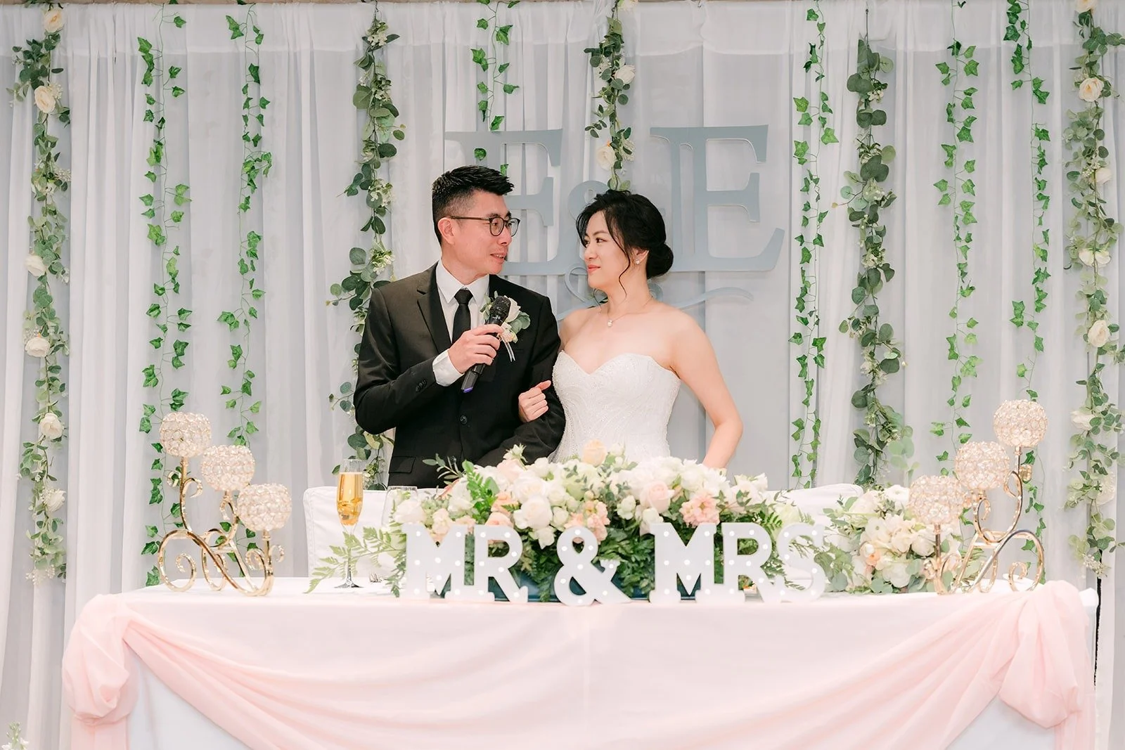 Eunice and Eric speak to their guests from the sweetheart table, photographed by One and Only Production