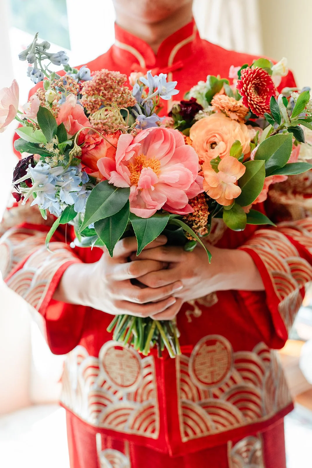 Bridgette holding her bouquet against her qun kwa.