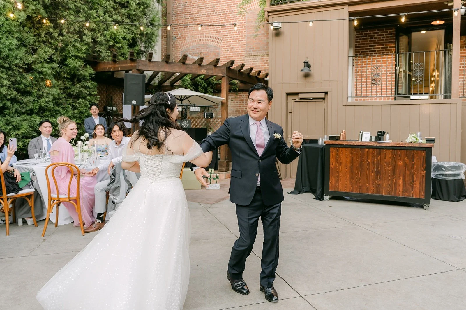 Chorok and her dad sharing a dance as guests watch