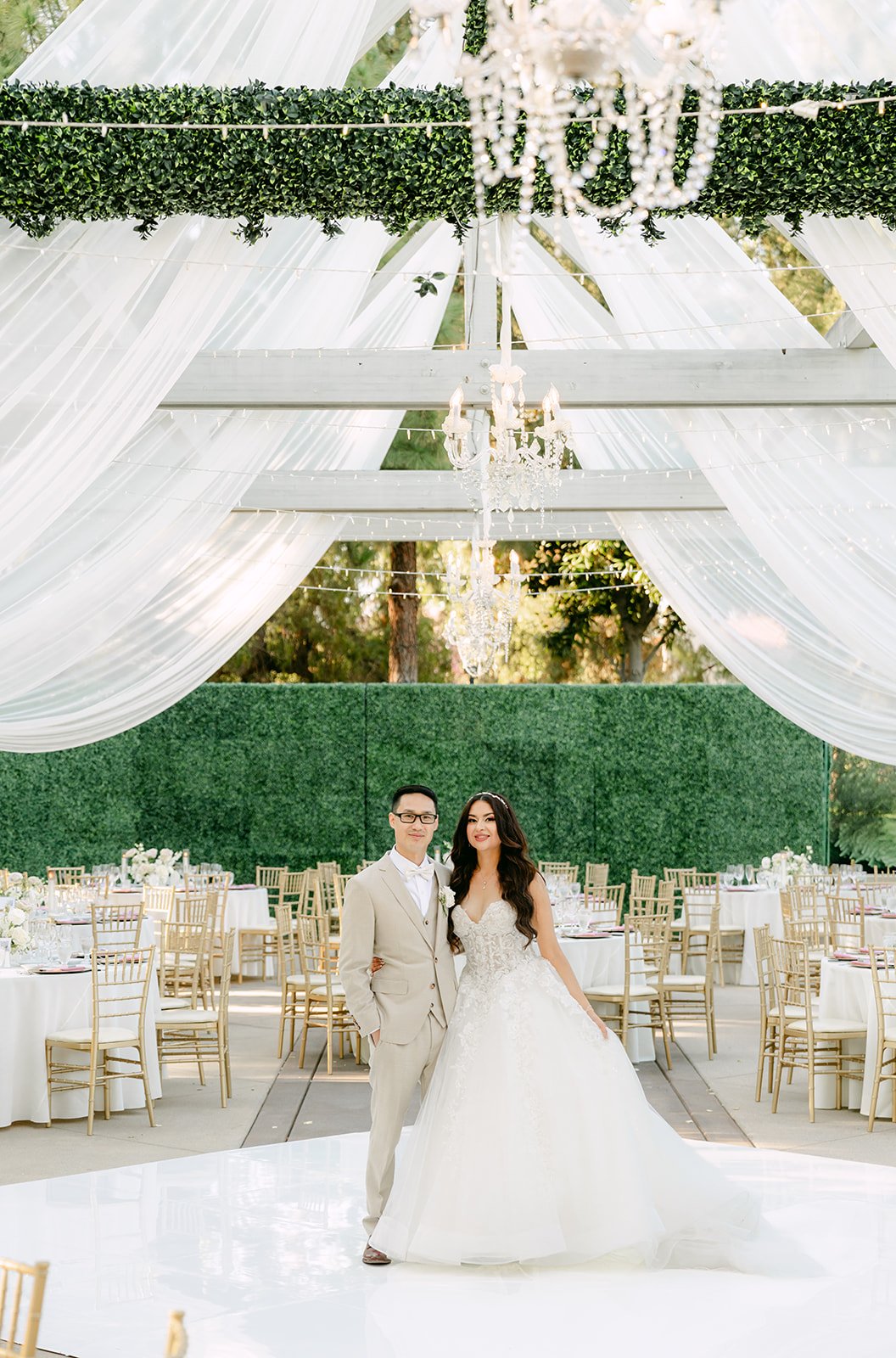 Sandra and Kevin alone in the reception under the chandeliers, photographed by One and Only Production.