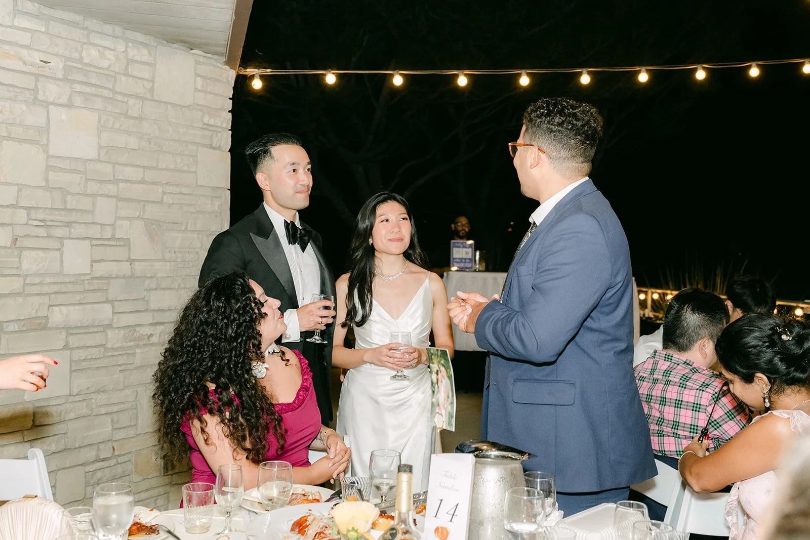 Table greetings with friends under the string lights