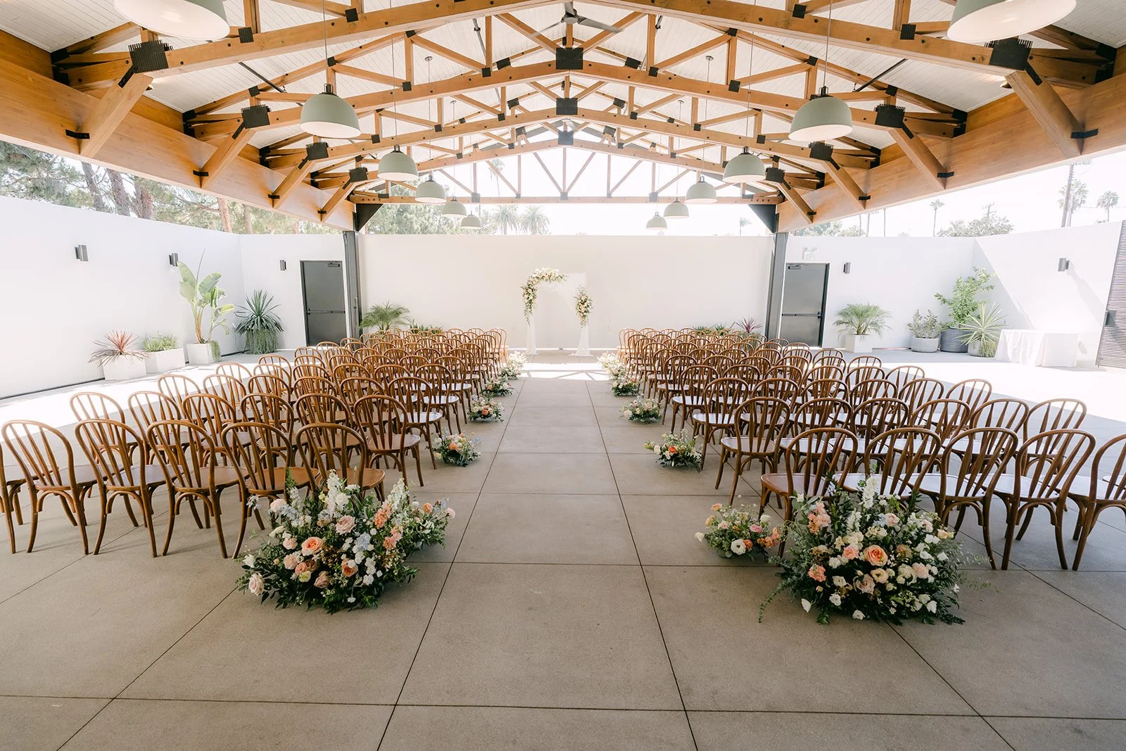Ceremony chairs under the wood trusses of the Colony House Pavilion in Anaheim