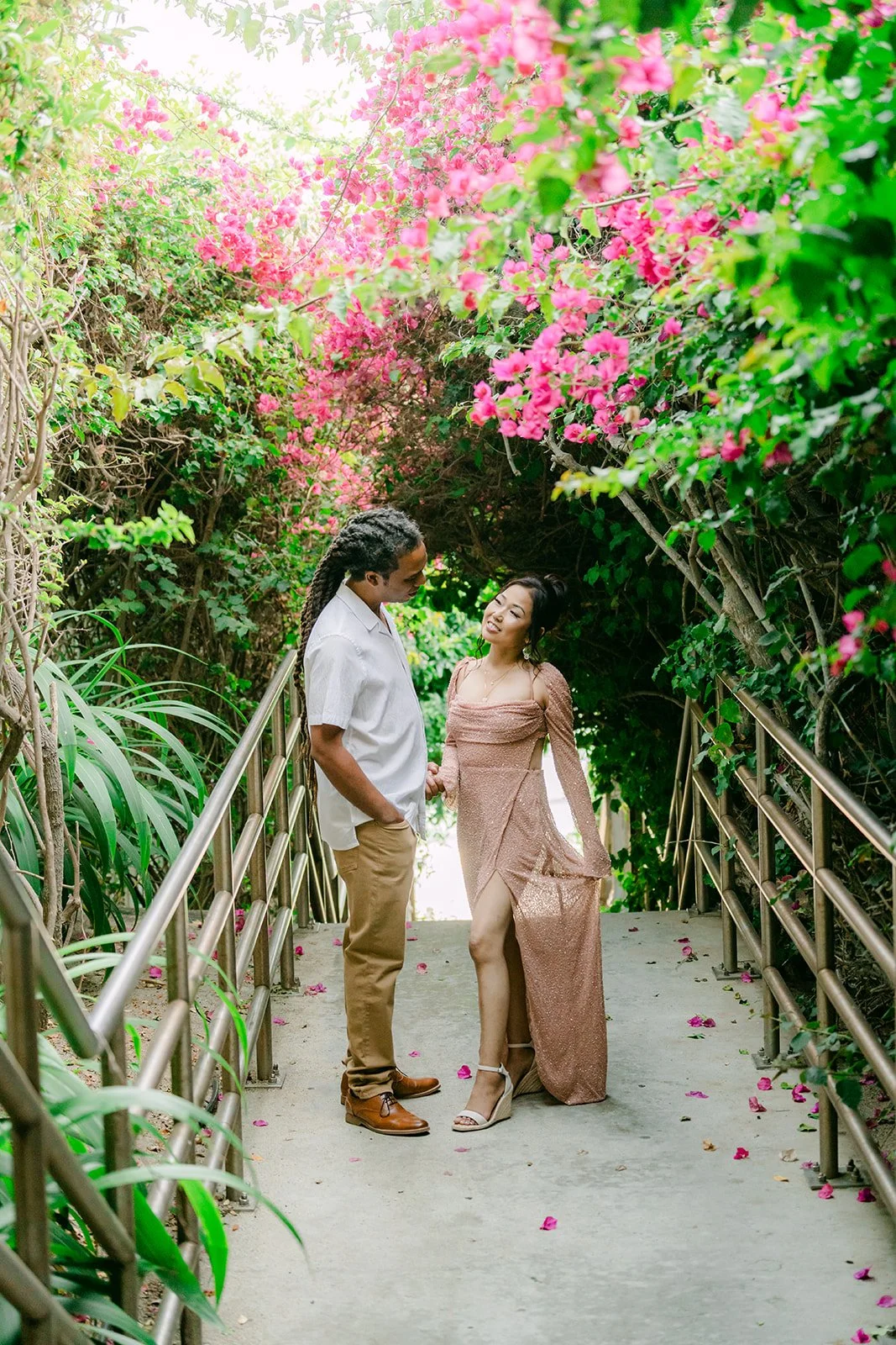 Amy and Michael smiling on the flower-covered stairs.