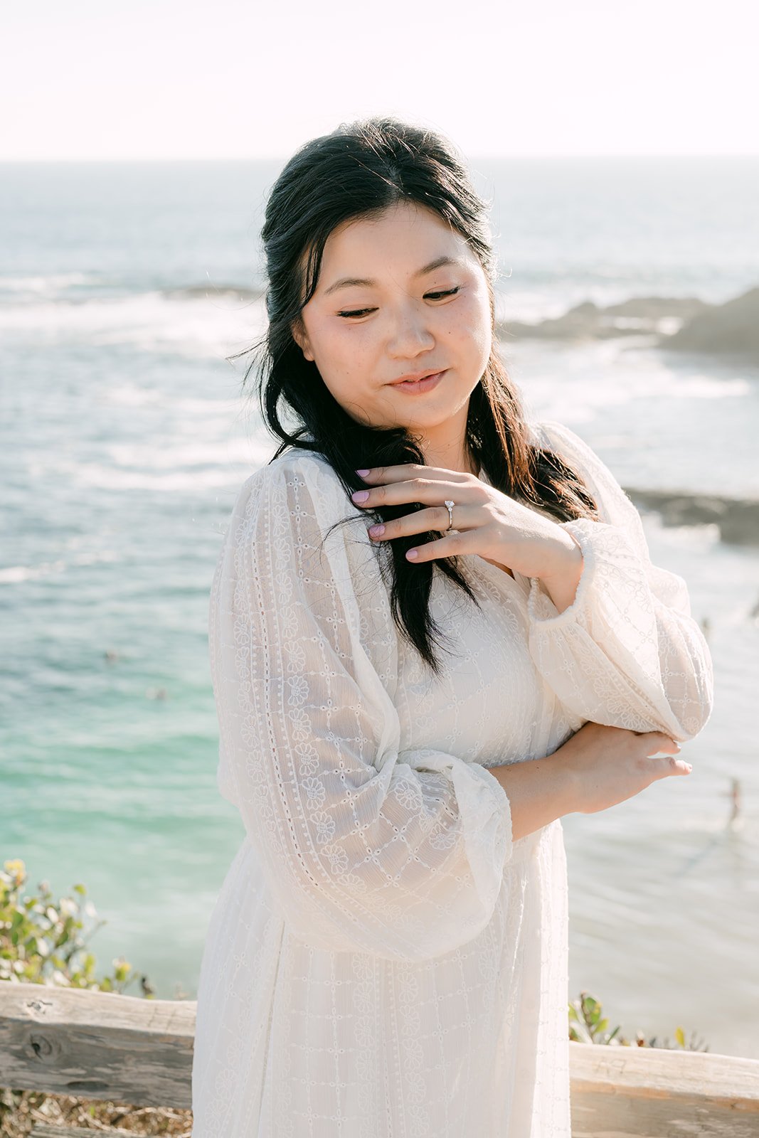 Constance in white with the ocean behind her.