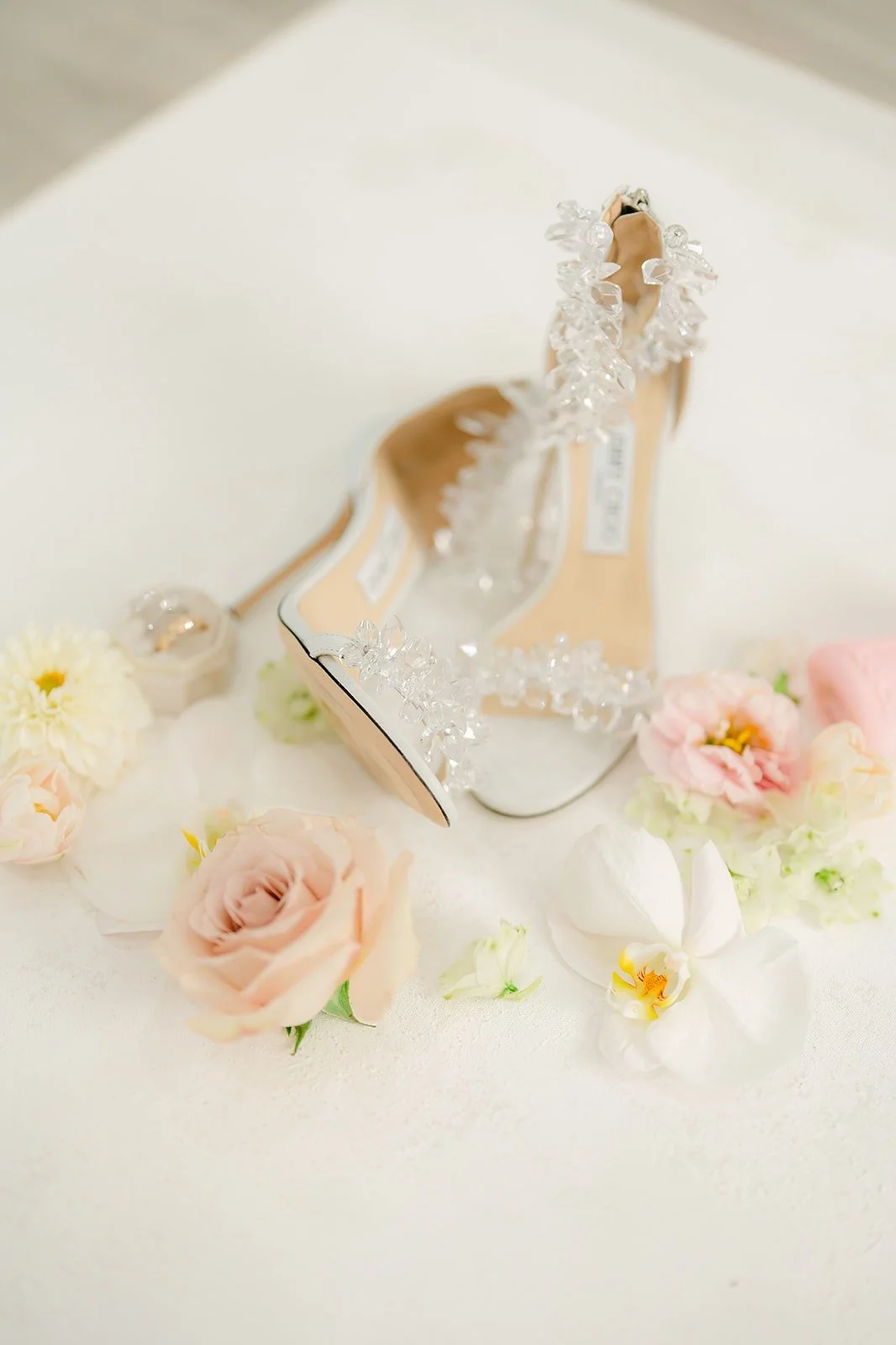 Candice's crystal embellished heels among white and blush roses
