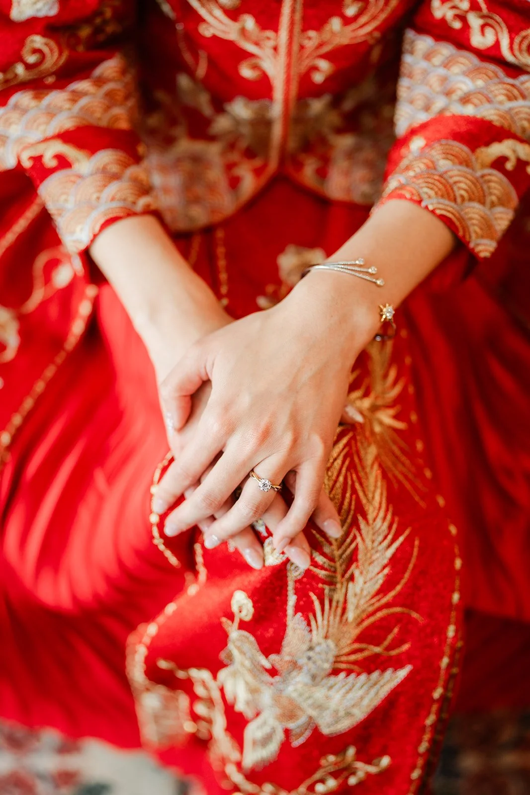 Bridgette's hands resting on her embroidered qun kwa.
