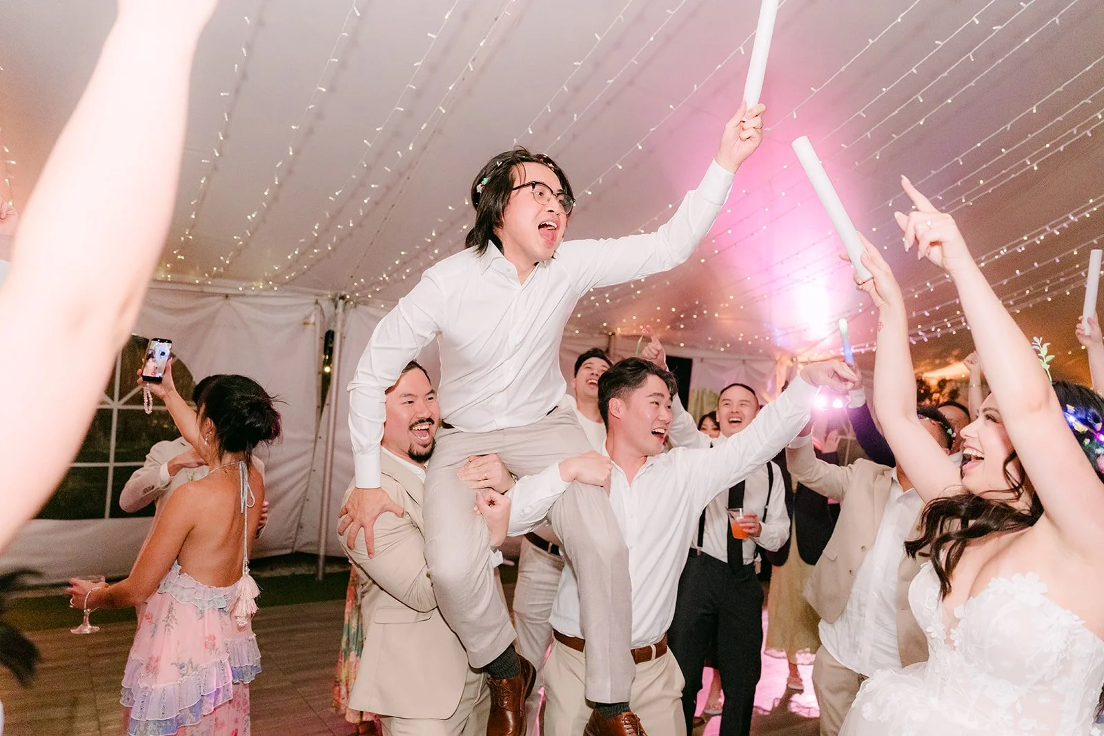 Mike lifted onto his friends' shoulders on the dance floor