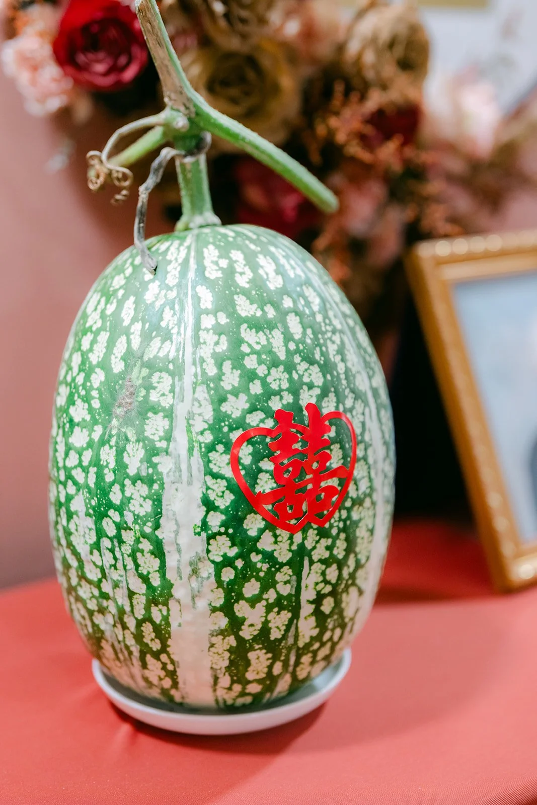 A painted wedding melon with a double happiness character on the tea ceremony table.