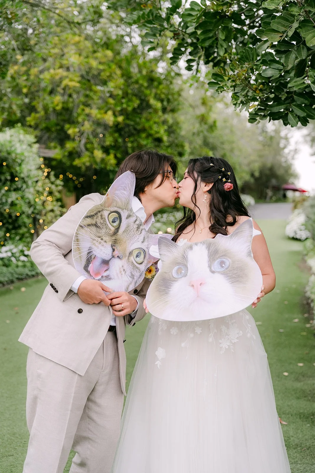 Couple kissing while holding cat face cutouts