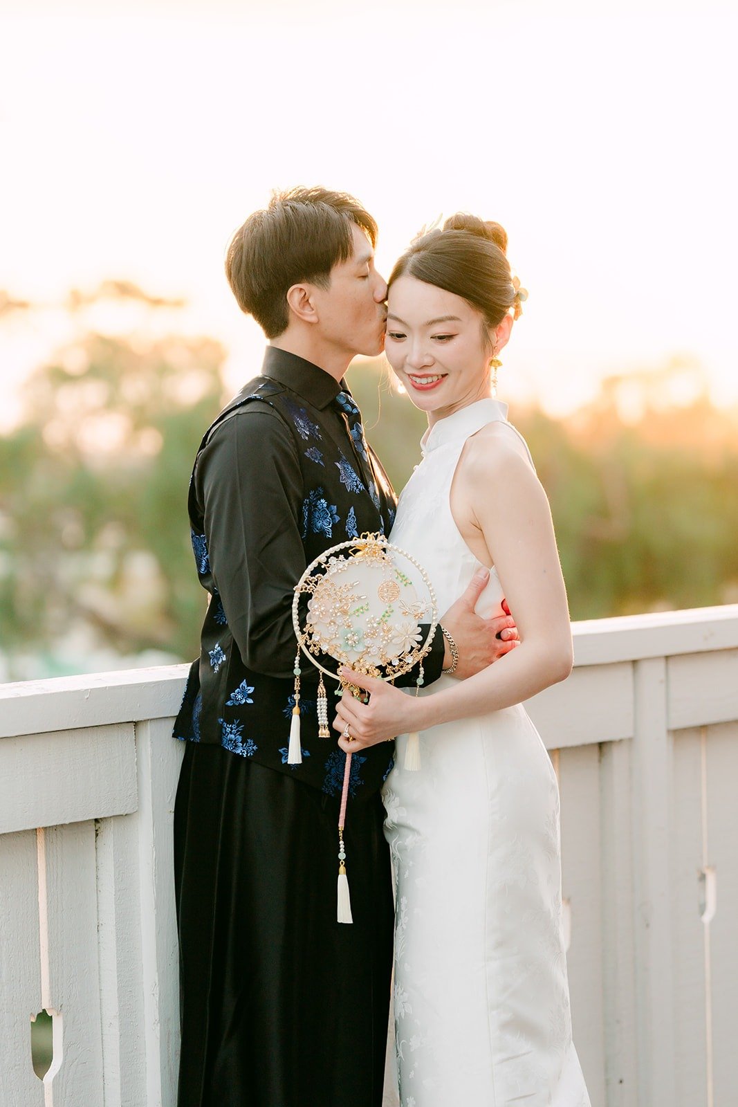 Tin and Fong at sunset holding a round fan