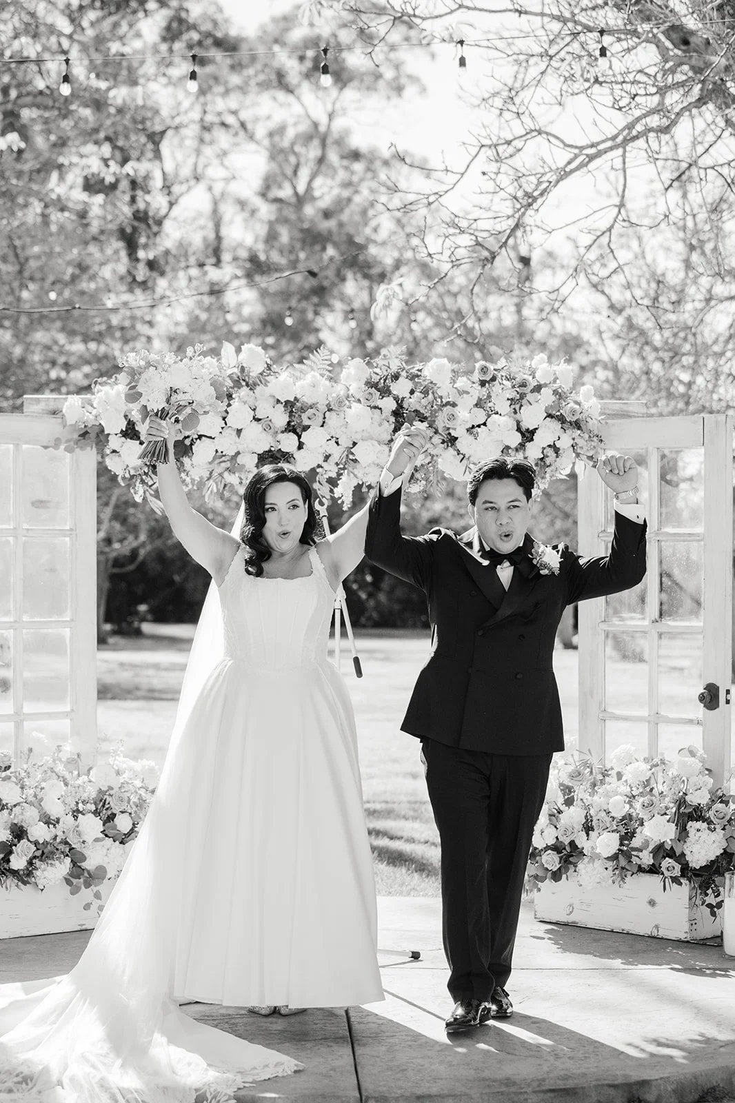Black and white photo of the couple celebrating at the end of the aisle
