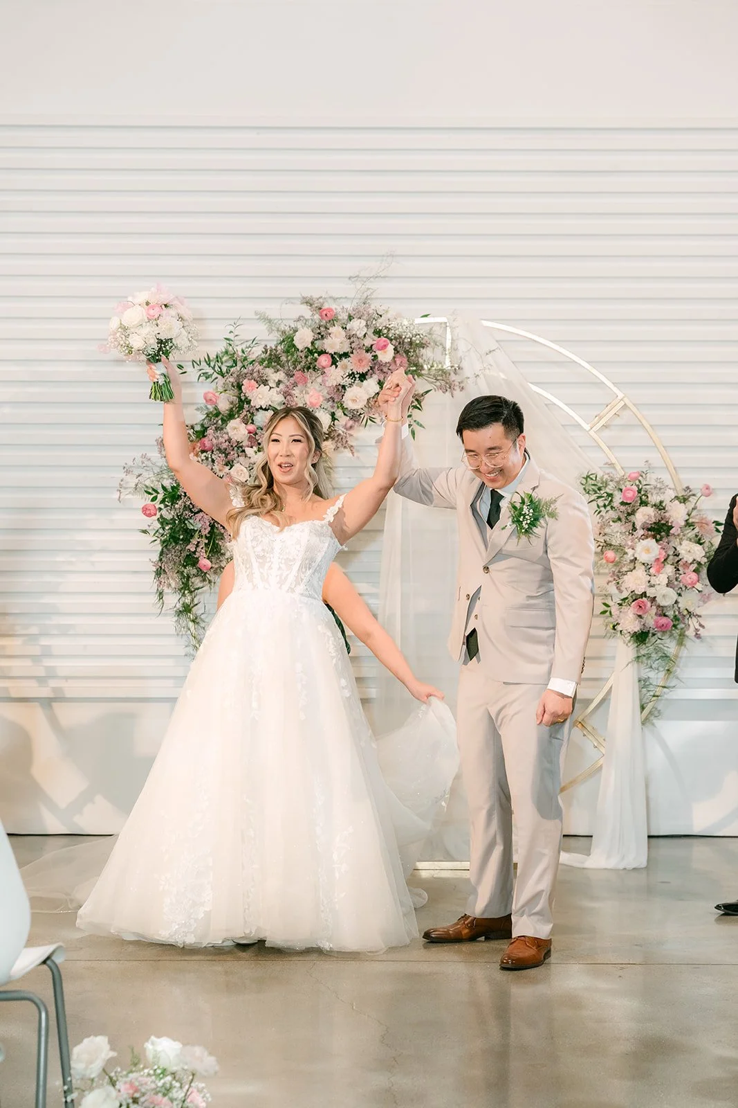 Newlyweds raising their arms in celebration after the ceremony