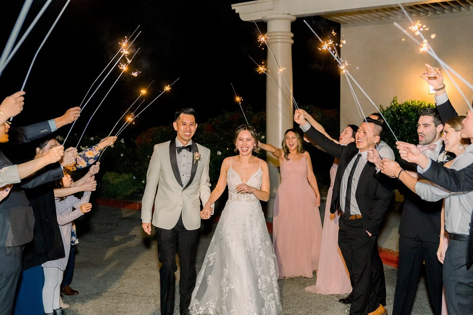 Josephine and David walking through the sparkler tunnel