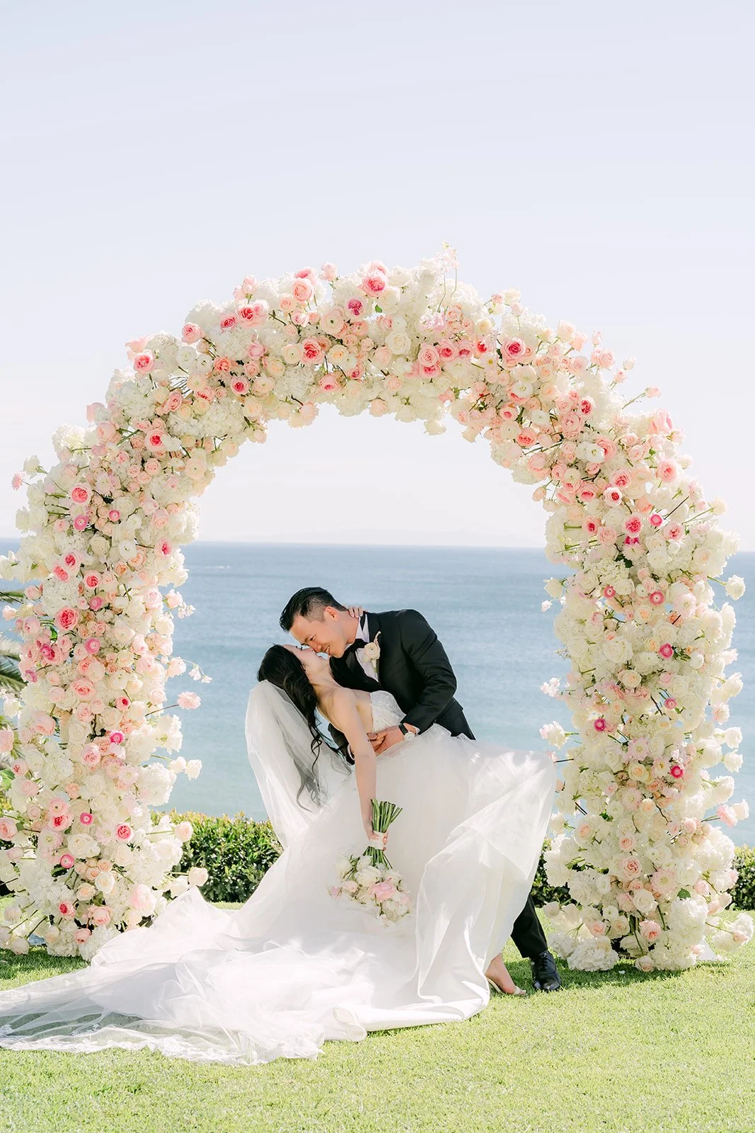 Kai dipping Kelley for a kiss under the rose arch
