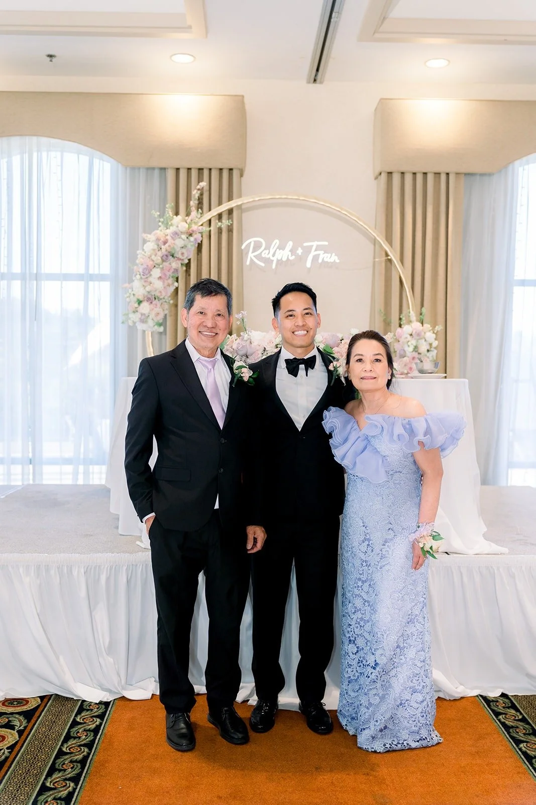 Francesca and Ralph with family in front of their neon sign