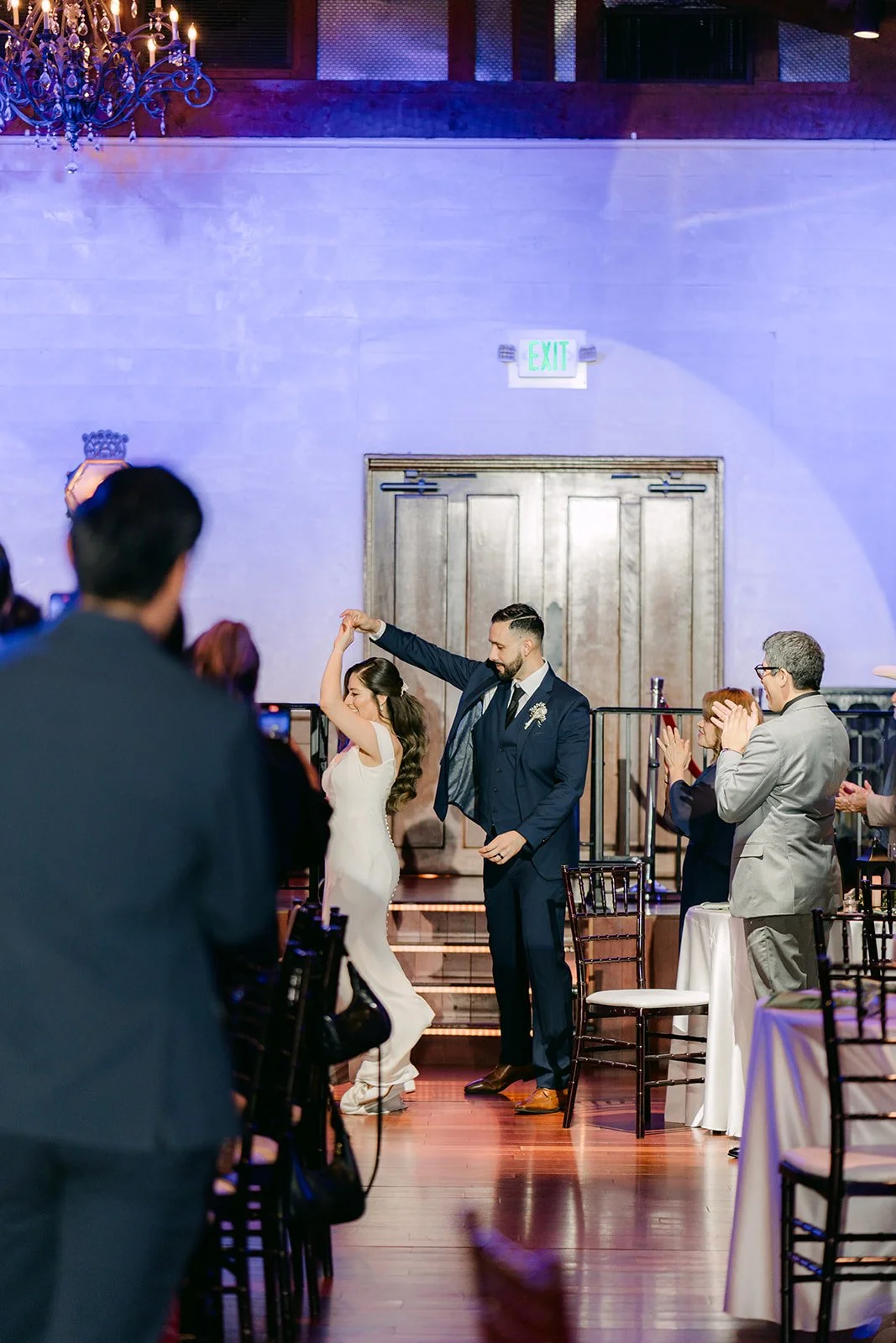 Guests cheering as the couple comes down into the reception room