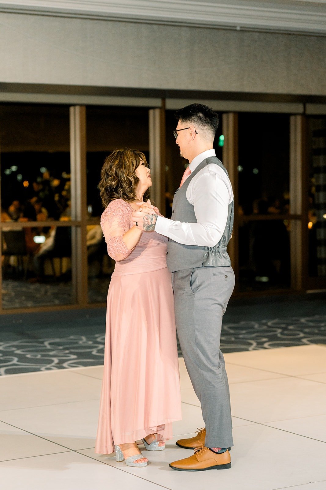 Mikey and a family member dance by the ballroom windows