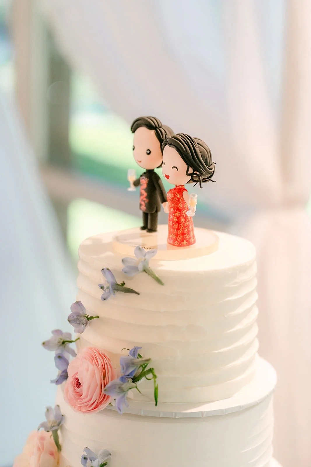 Wedding cake with a figurine topper of Florence and Jordan