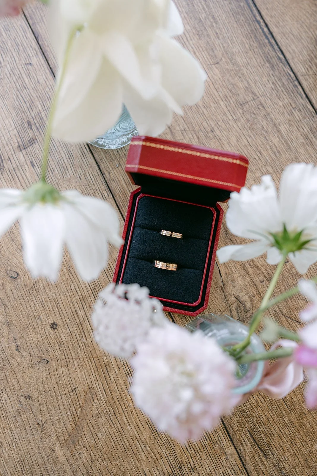 Red ring box with pastel flowers on a wood table