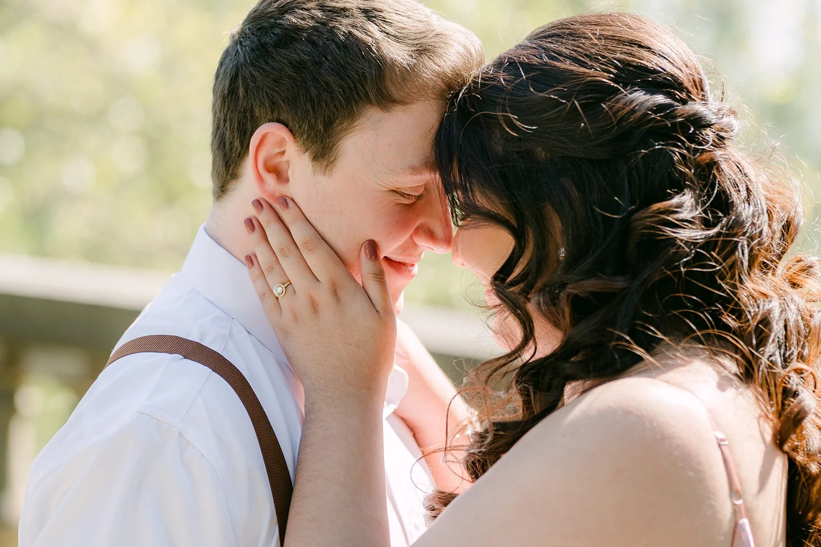 Saira and Matthew touching foreheads in the garden light.