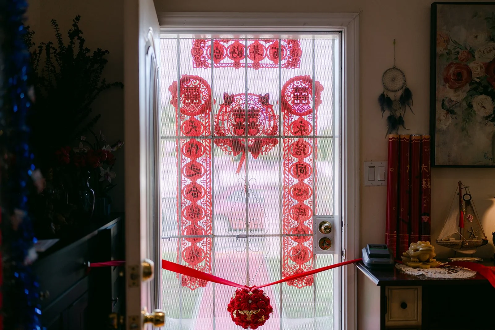 Double happiness papercuts and red ribbon framing the front entry before the door game.