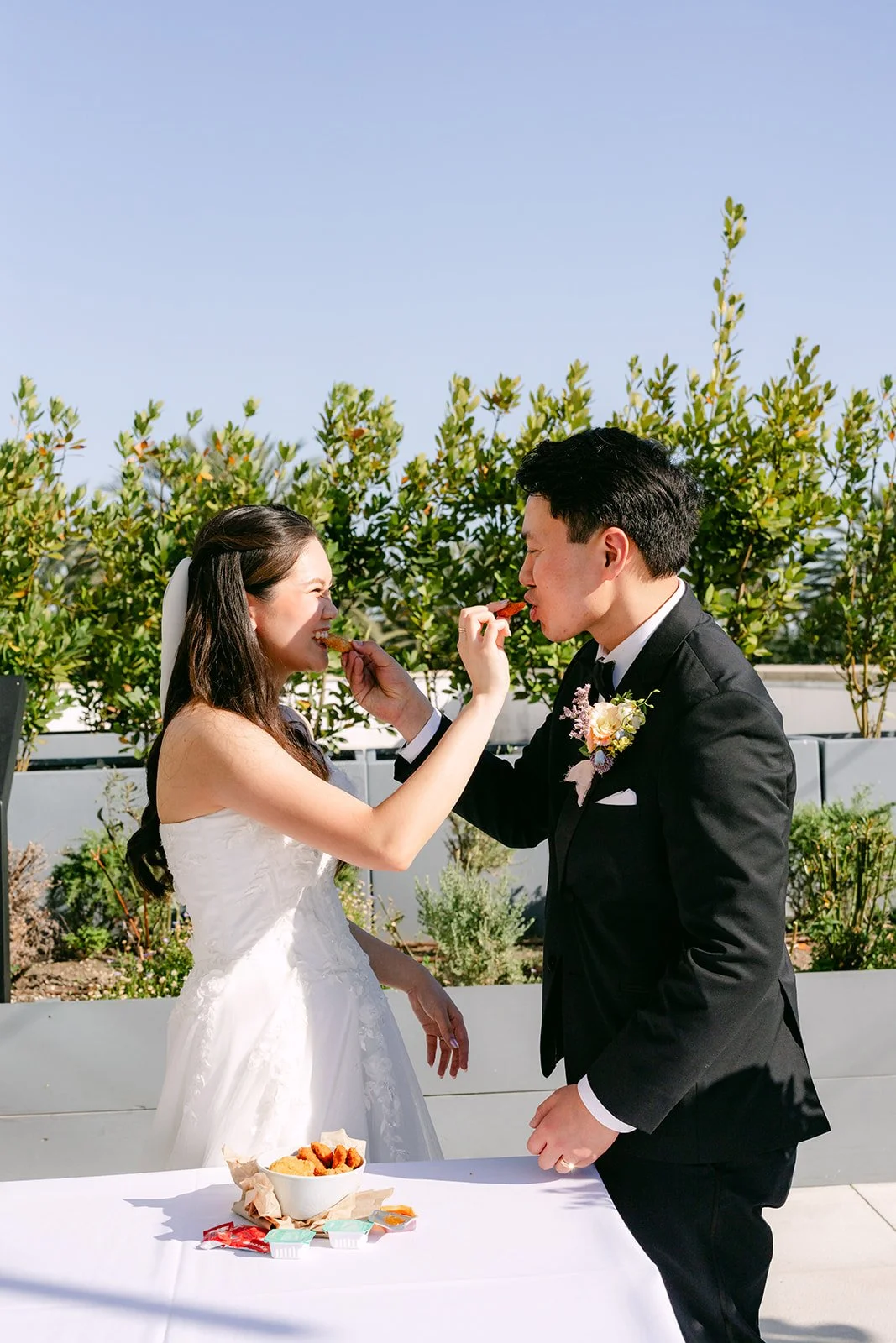 Linh and Hoan feeding each other during their chicken nugget unity ceremony