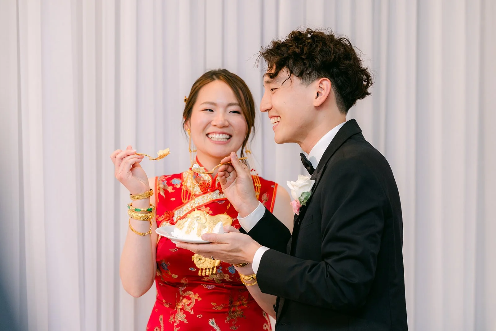 Couple cutting the wedding cake with Victoria in a red qipao