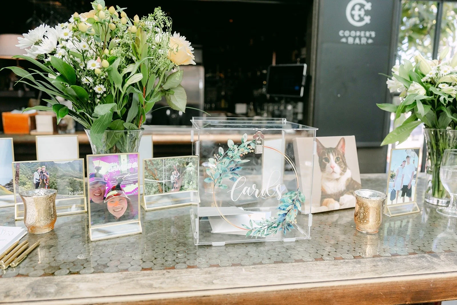 Framed photos, white florals and candles on a welcome table