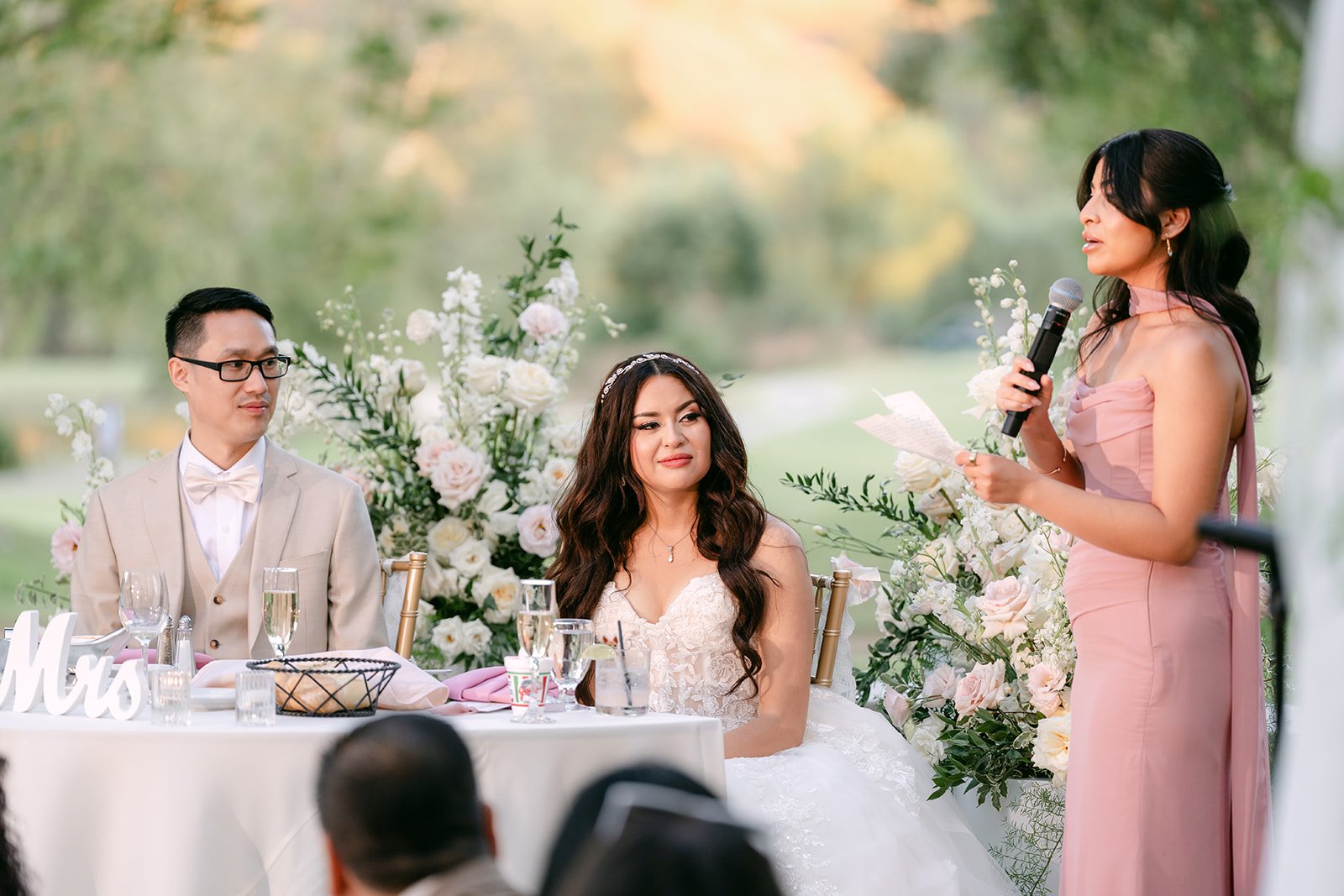 Maid of honor Eva giving her toast beside Sandra and Kevin's sweetheart table.