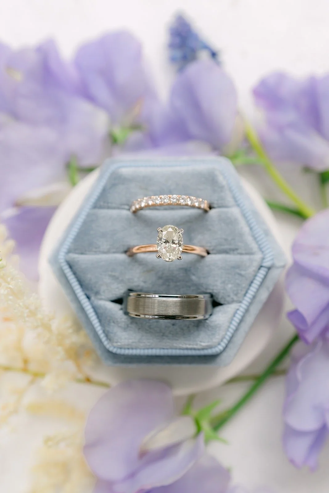 Close up of the engagement ring and bands in the blue velvet box