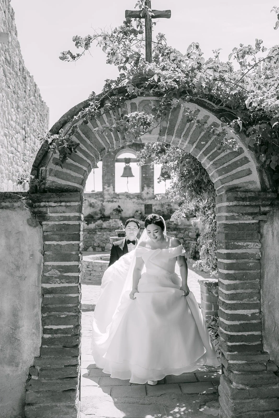 A black and white portrait of Chorok and Min Soo framed by a stone arch at the Mission, photographed by One and Only Production