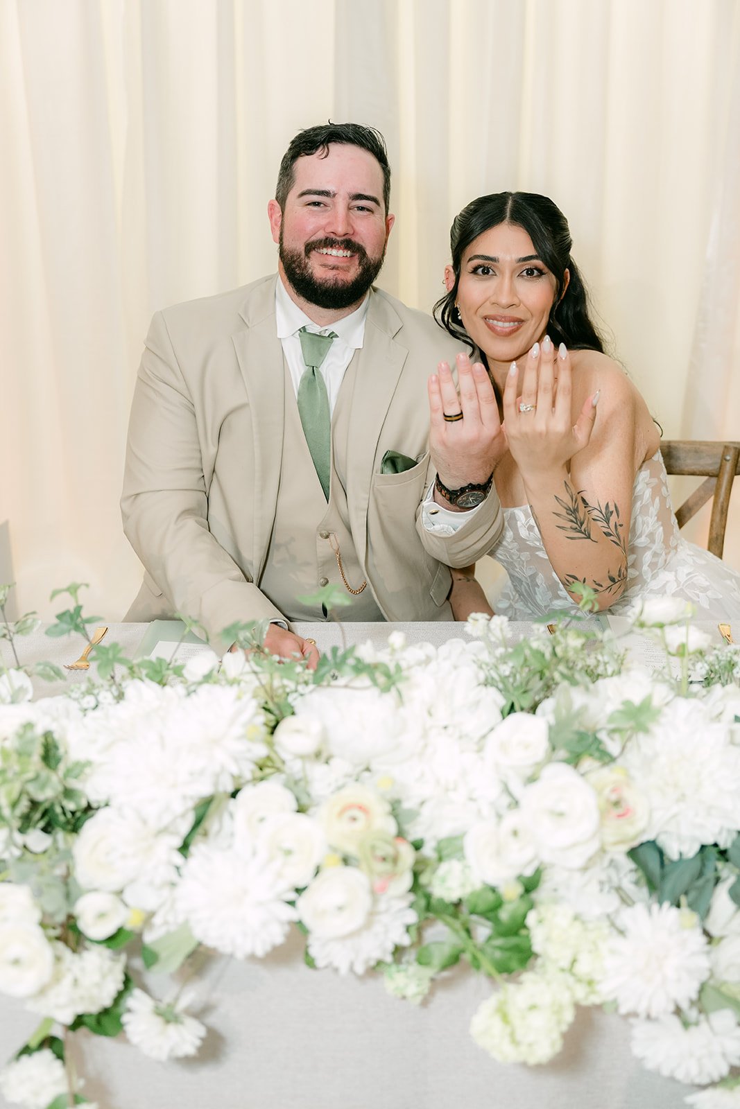 Fernanda and Cody laughing at the sweetheart table, photographed by One and Only Production.