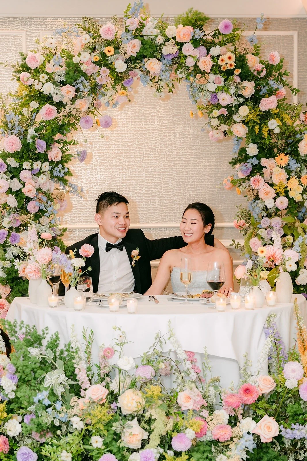 Kylie and Mario at their sweetheart table listening to the toasts