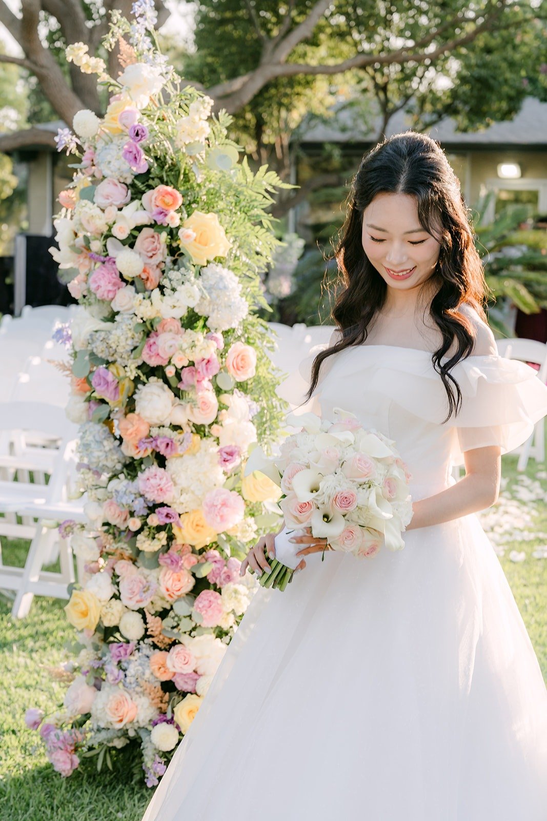 Jeannie holding her bouquet beside the floral column