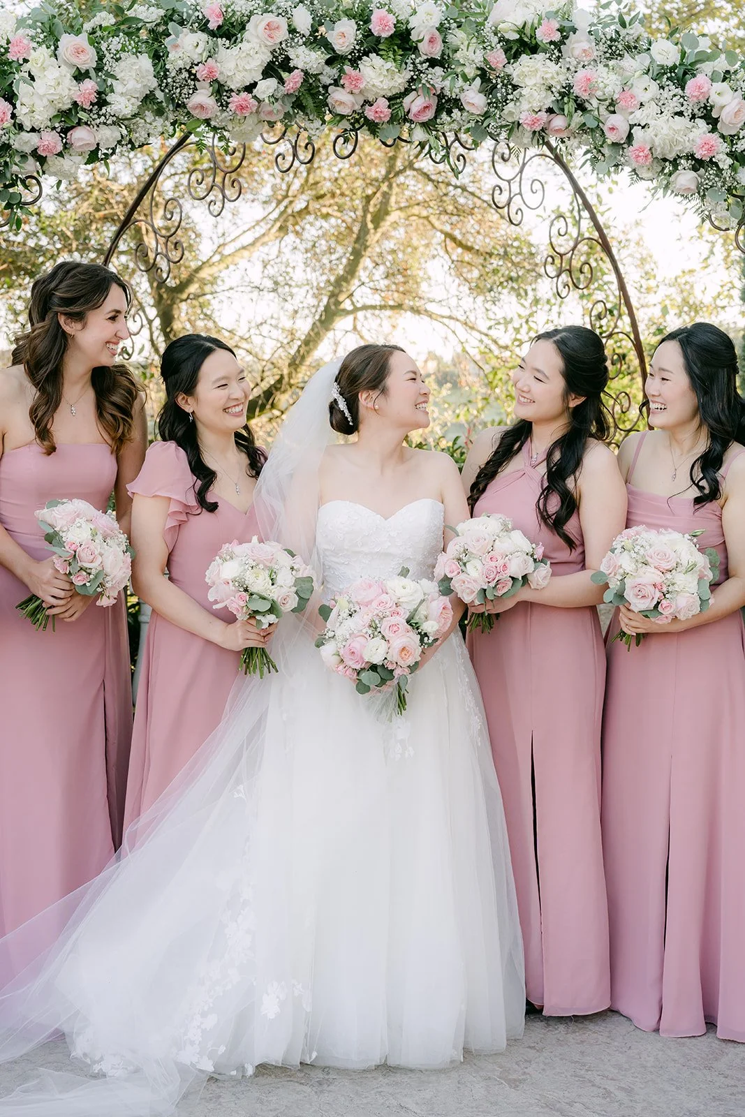 Bride laughing with her bridesmaids holding matching bouquets