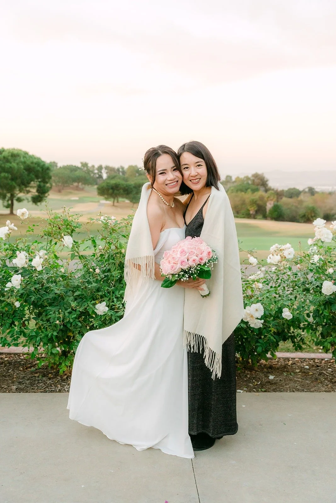 Ivy hugging a guest with her pink rose bouquet