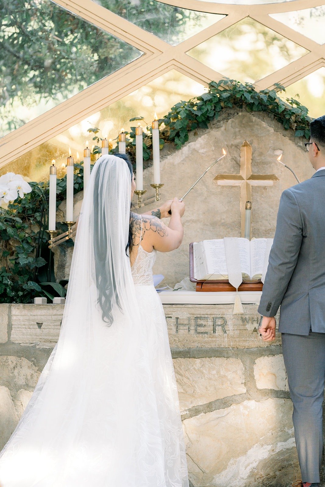Betsy and Mikey at the altar table beneath the stone wall of the chapel