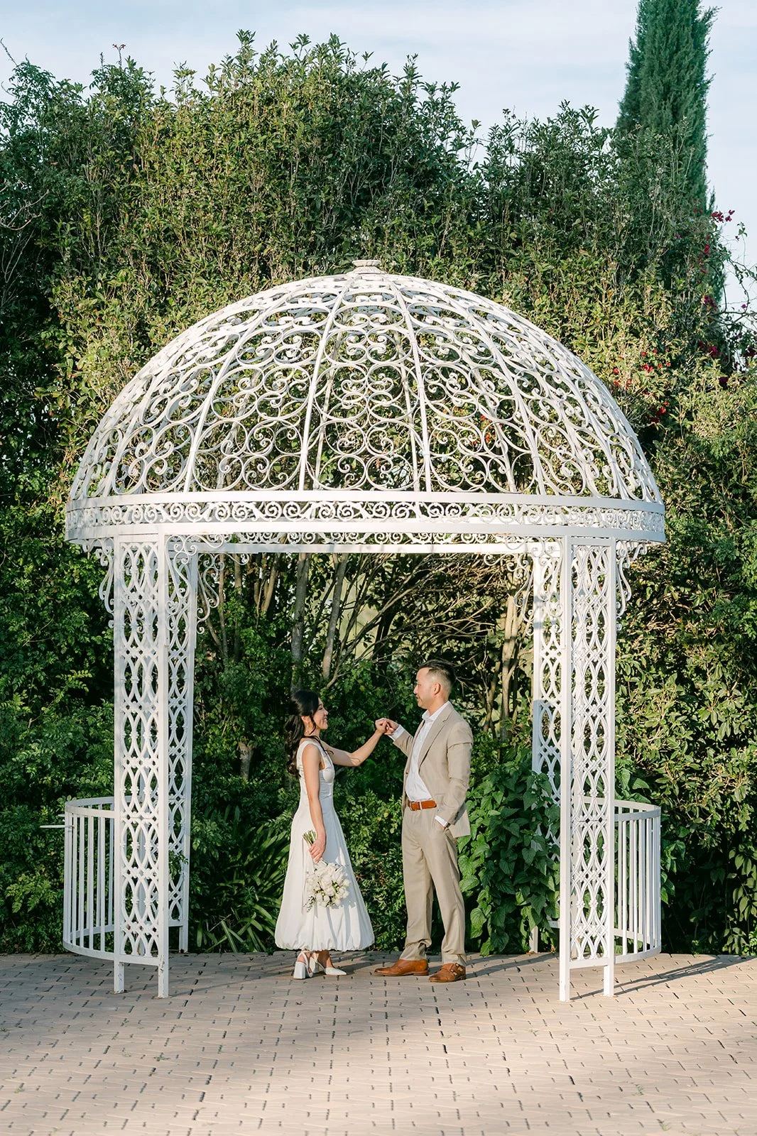 Kim and Vincent holding hands under the gazebo's lattice dome.