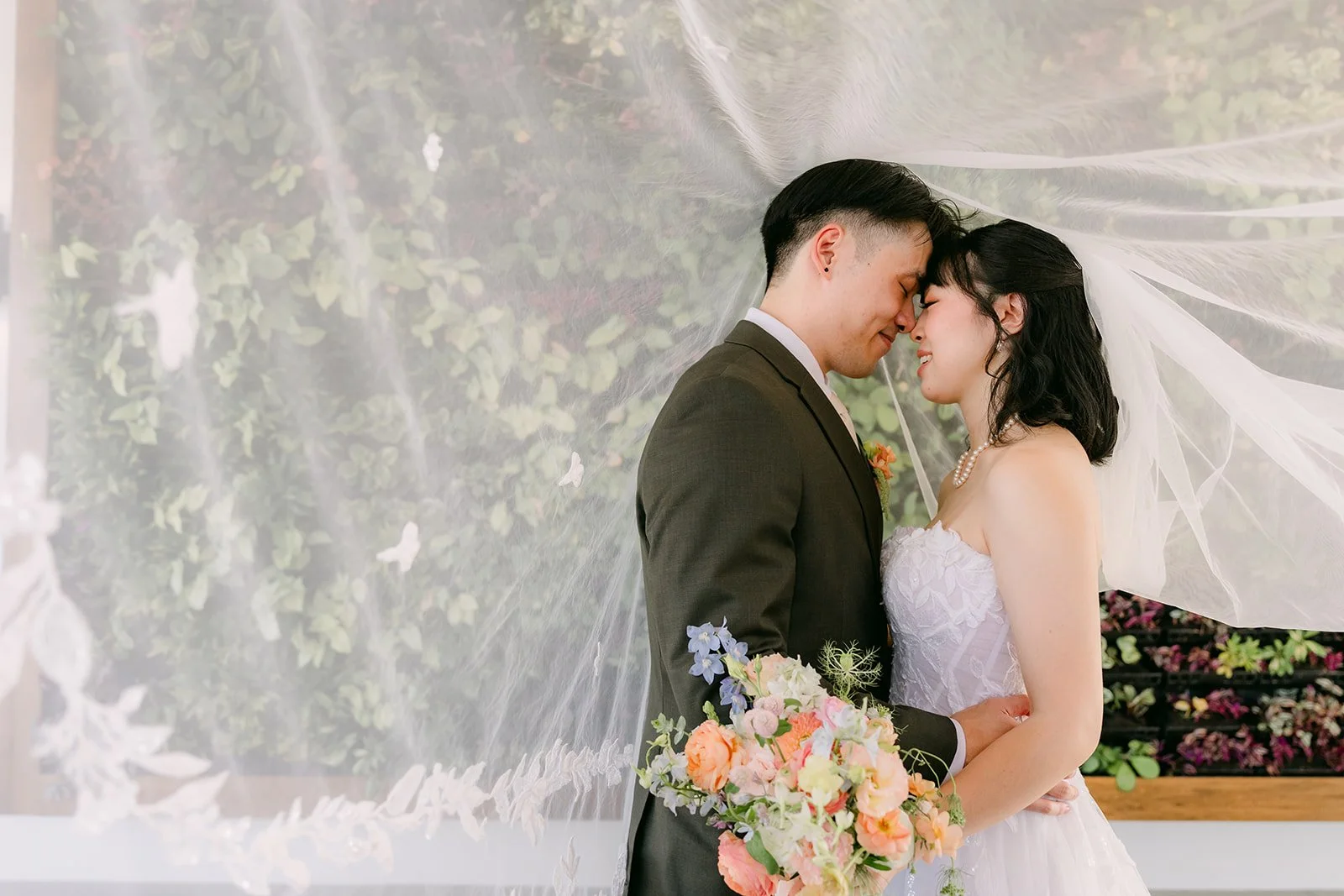 Vivian and Alex with foreheads together under the veil
