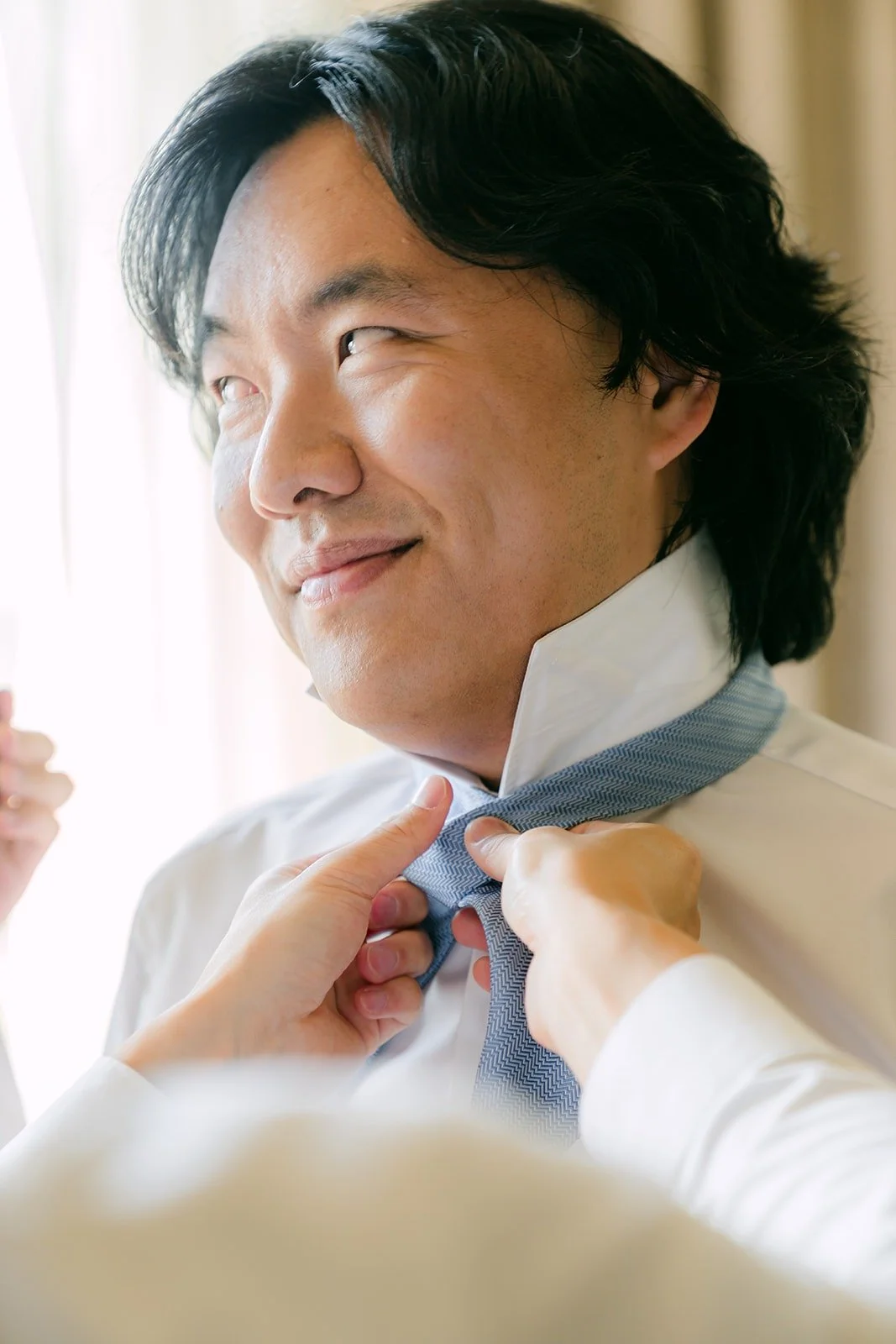 Philip smiling while his tie is adjusted