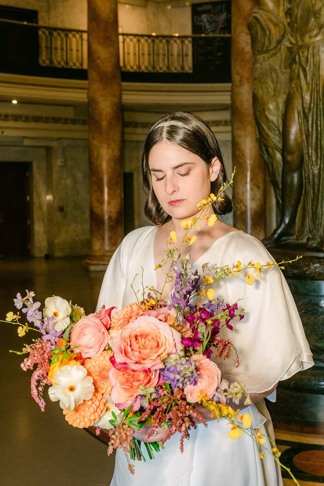 Jessie holding her bouquet of peach roses and violet blooms