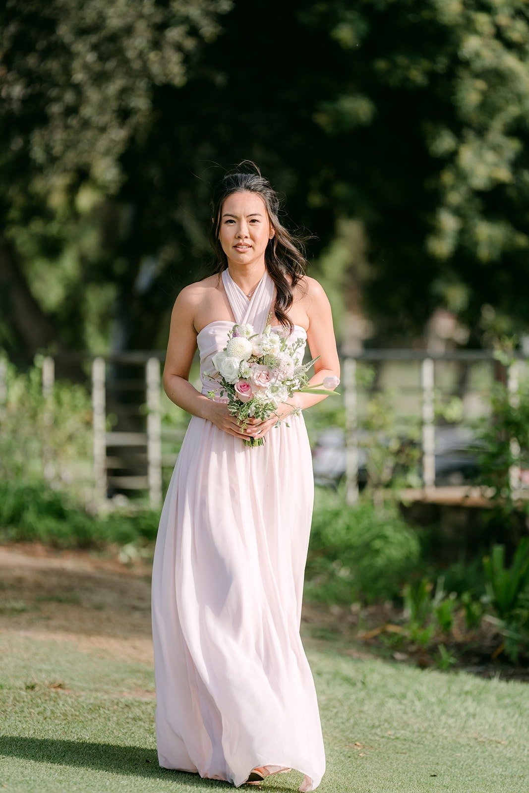 A bridesmaid walking down the aisle with her bouquet