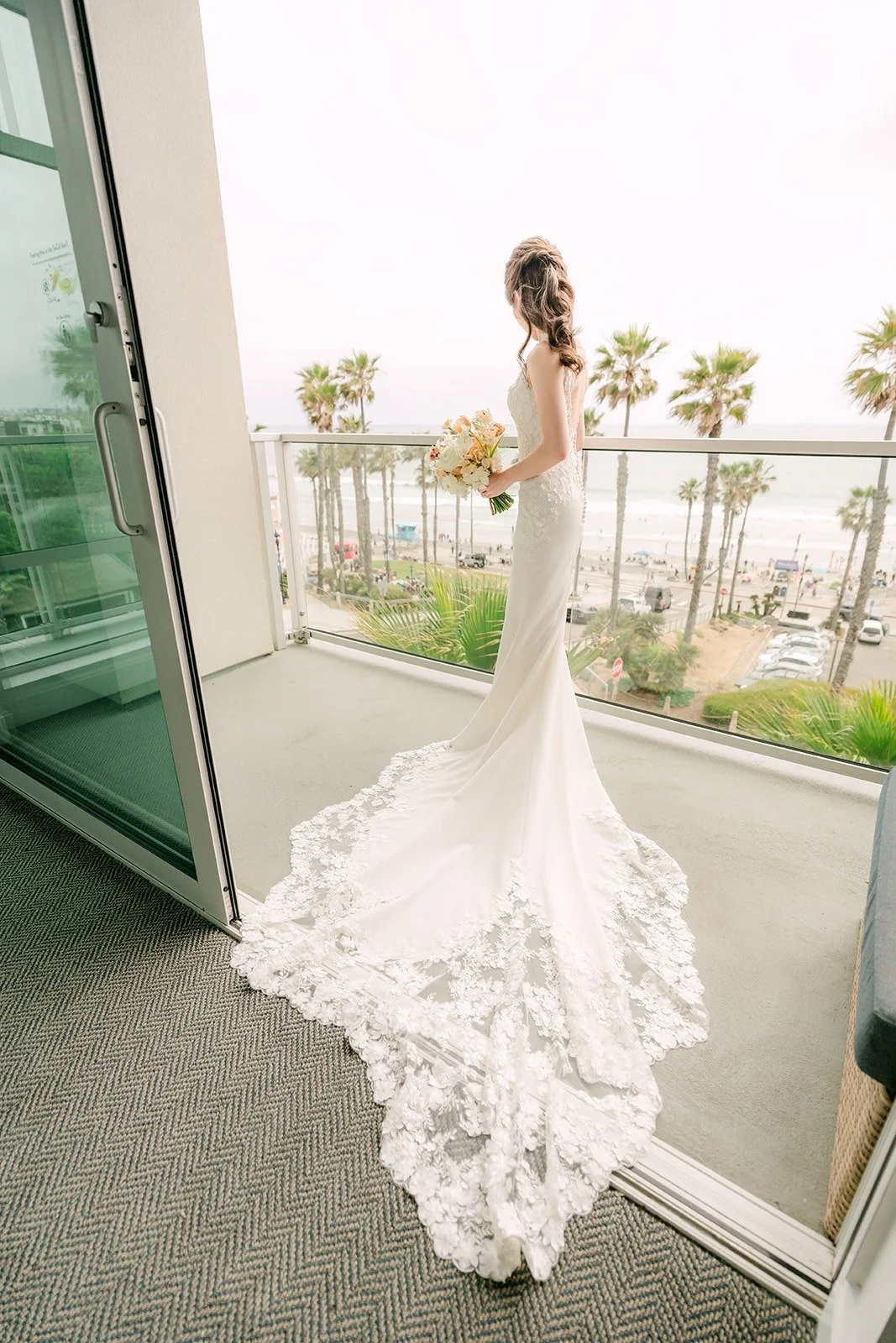 Angela on a balcony at Seabird Resort with her lace train spread behind her