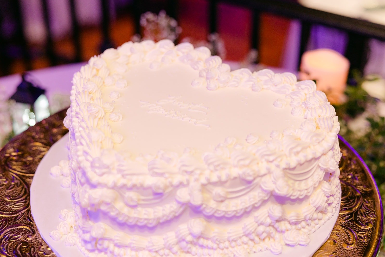 A white heart shaped cake with piped ruffles
