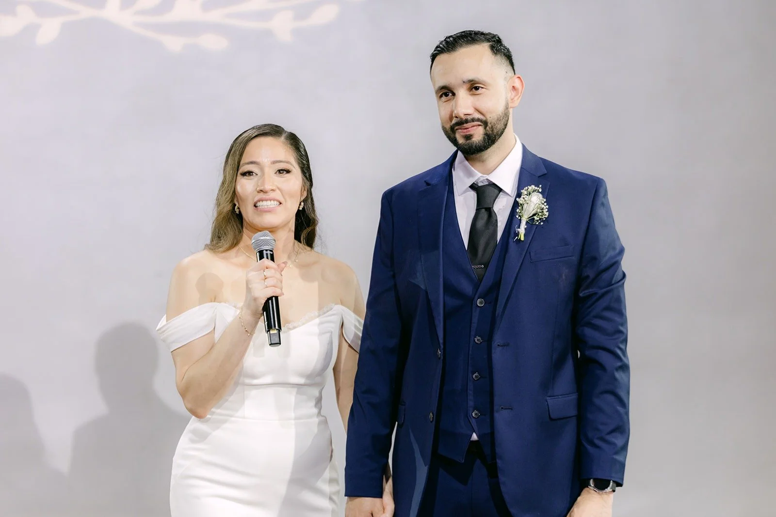 Mariana and Danny thanking their guests with the microphone