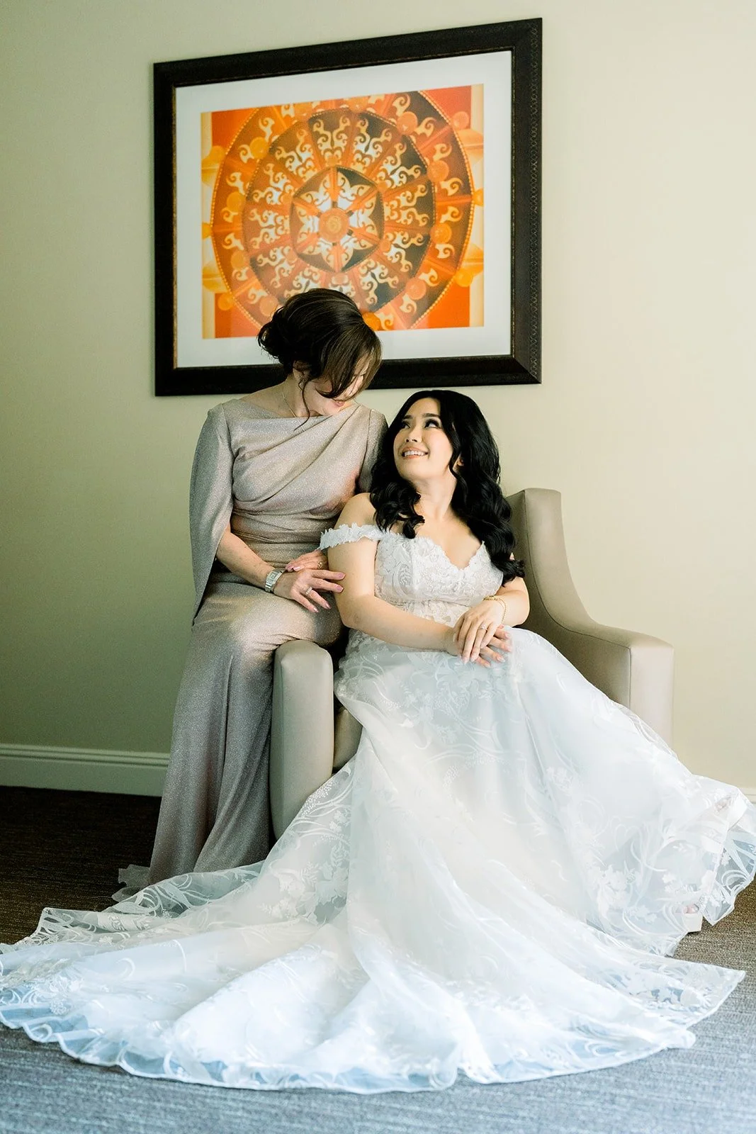 Francesca seated in her gown beside a family member in a silver dress