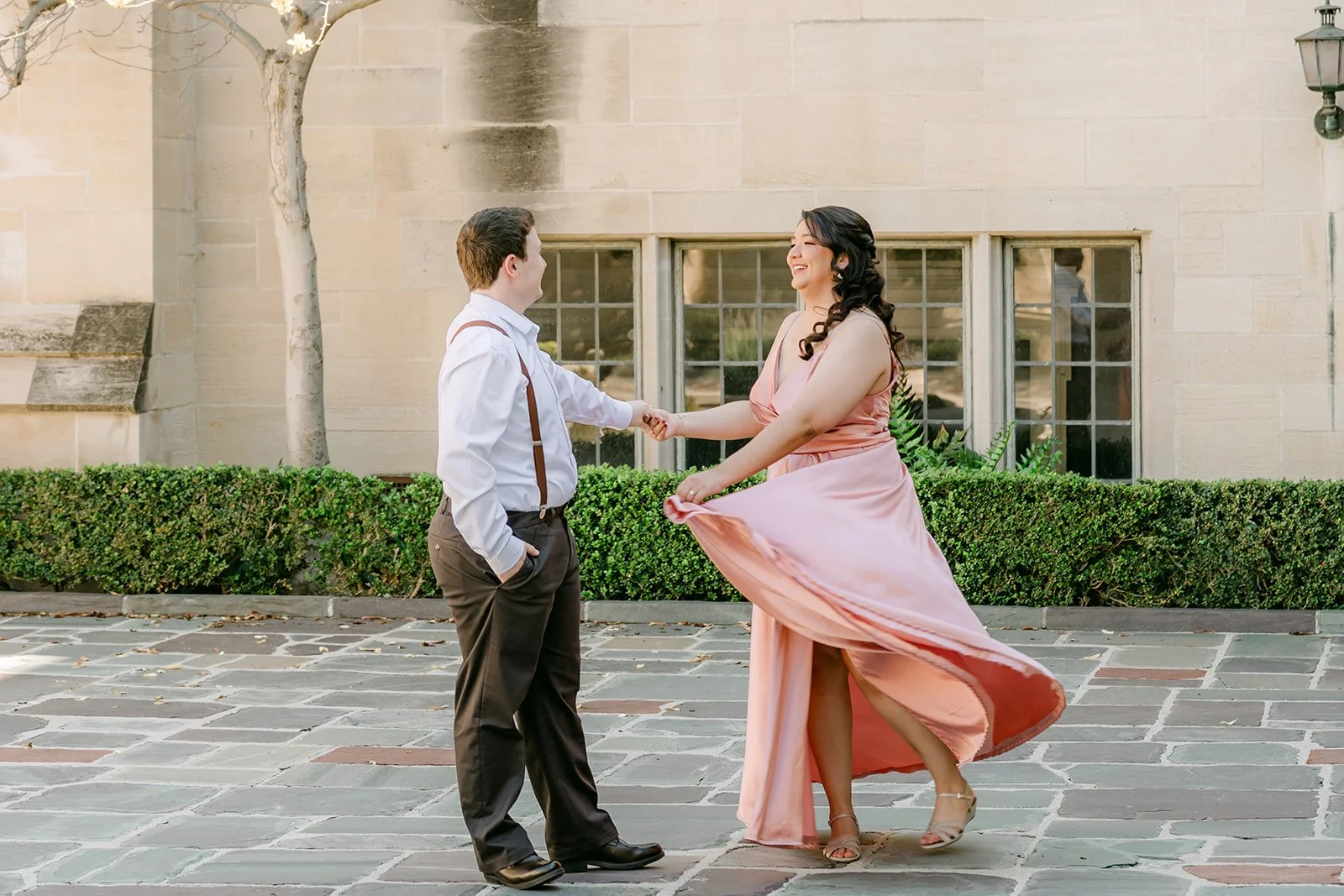 Saira's gown swirls as Matthew spins her across the courtyard.