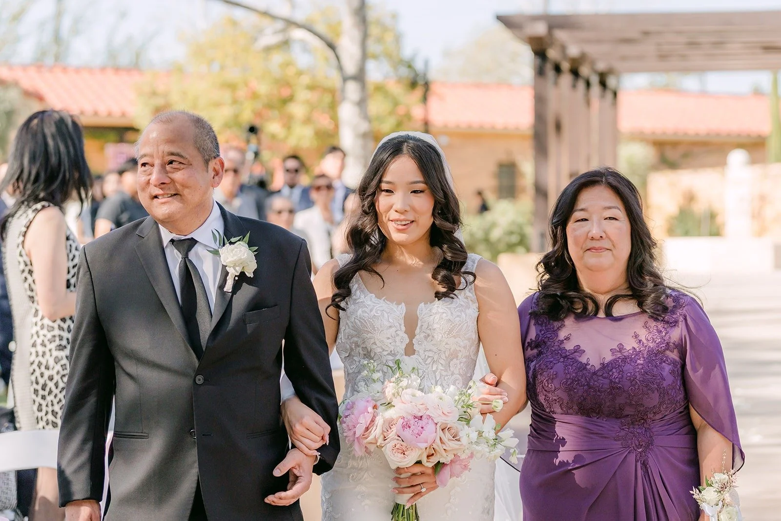 Kelli walking down the aisle with both of her parents